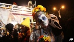 Costumed participants in the Village Halloween Parade pose for photographs as they make their way up Sixth Avenue Monday, Oct. 31, 2011 in New York. The annual Halloween Parade kicked off Monday evening. Anyone in costume is welcome to march in the event,