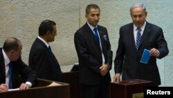 Israel's Prime Minister Benjamin Netanyahu (R) casts his ballot for the presidential election at the Knesset, Israel's parliament in Jerusalem, June 10, 2014. 