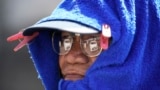 热浪袭击东南亚，菲律宾一名男子以毛巾裹着头部以防晒伤。（美联社）