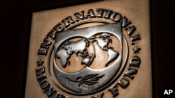 The logo of the International Monetary Fund is visible on their building, Monday, April 5, 2021, in Washington. The IMF and the World Bank open their virtual spring meetings. (AP Photo/Andrew Harnik)