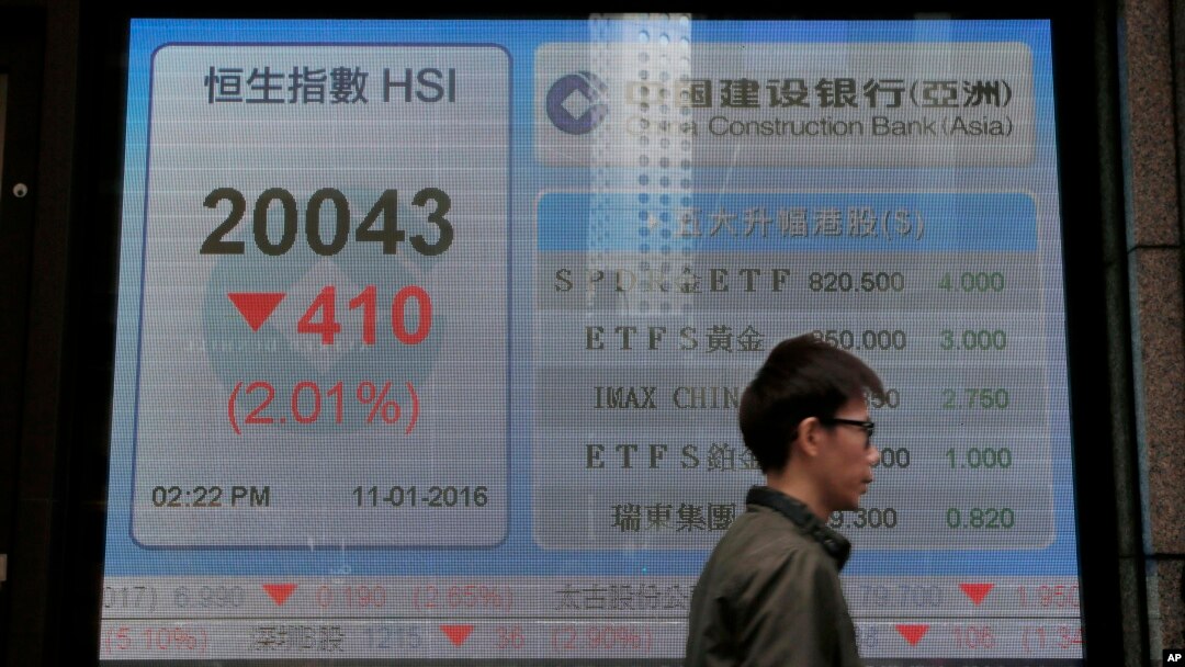 一位男士走过香港一家银行外显示香港股指的电子屏幕。（2016年1月11日）
