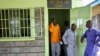 FILE - A prisoner, center, who aids his fellow inmates with writing legal documents, stands with them at Naivasha Prison in Kenya, Oct. 31, 2018.