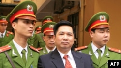 Công an áp giải Tiến sĩ Cù Huy Hà Vũ ra khỏi tòa sau phiên xử ở Hà Nội hồi đầu tháng tư