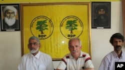 Serokê BDP'ê Halîs Yurtsever û rêvebirên bajarê li avahîya partîyê xwane dibin.