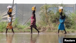 Des déplacés transportent de la nourriture de secours dans les eaux de crue à Gumuruk, dans l'État de Boma, dans la région du Grand Nil Supérieur au Soudan du Sud, (Reuters)