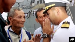 In this photo taken Dec. 3, 2010, U.S. navy officer Michael "Vannak Khem" Misiewicz, right, greets his relatives at Cambodian coastal international see port of Sihanoukville, about 220 kilometers (137 miles) southwest of Phnom Penh, Cambodia. Misiewicz finally returned home Friday as commander of the U.S. Navy destroyer USS Mustin, reuniting with the relatives who wondered whether they would ever see him alive, and the aunt who helped arrange his adoption. His ship departs Monday. (AP Photo/Heng Sinith)