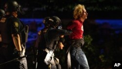 Portland police make arrests on the scene of the nightly protests at a Portland police precinct on Sunday, Aug. 30, 2020 in Portland, Ore. Oregon State Police will return to Portland to help local authorities after the fatal shooting of a man…