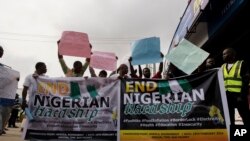 FILE —People hold banners and protest due to the economic hardship in Ibadan, Nigeria, February 19, 2024.