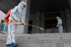 Personal de la Escuela Primaria No. 4 de Pyongyang trabajan con desinfectante en aerosol en Pyongyang, Corea del Norte, el 30 de junio de 2021.