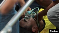 Choirul Huda, kiper Persela Lamongan, menerima perawatan medis setelah mengalami cidera dalam pertandingan melawan Semen Padang di Lamonga, 15 Oktober 2017. (Antara Foto/Rahbani Syahputra via REUTERS )