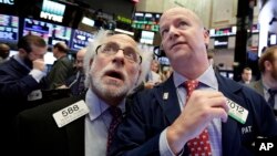 Para pialang di Wall Street mengamati saham-saham Amerika turun tajam hari Kamis (8/2). 