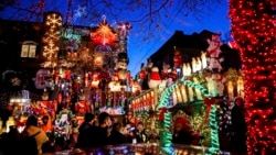 Turis melihat rumah yang dihiasi lampu Natal di kawasan Dyker Heights, Brooklyn, New York, Rabu, 21 Desember 2022. (Julia Nikhinson/AP)