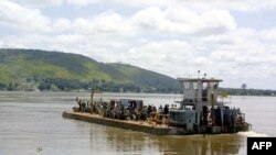 Quelques personnes traversent la rivière Ubangui à bord d’un bateau, RDC, le 10 novembre 2002.