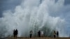 People take photos of the spray from waves crashing against the Malecon seawall, brought by the passing of Hurricane Milton in the Gulf of Mexico in Havana, Cuba, Oct. 9, 2024