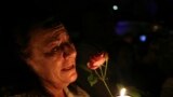 A woman cries as she holds a candle and a flower outside former South African President Nelson Mandela&#39;s house in Houghton, Dec. 5, 2013a