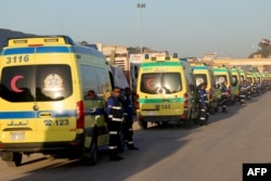 Red Crescent ambulances wait to enter the Palestinian side of Rafah on the Egyptian border with Gaza on Dec. 11, 2023.