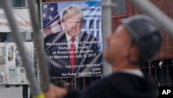 Workers build a podium that President Donald Trump will speak from during a visit to Poland this week in Krasinski Square in Warsaw, Poland, July 3, 2017. 