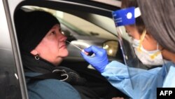 Petugas medis melakukan test Covid-19 terhadap para pengemudi di Melbourne (foto: ilustrasi). 