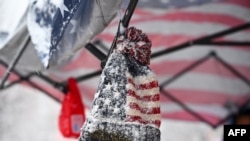 Un sombrero congelado cubierto de nieve se ve en un puesto de vendedores de recuerdos en Washington, DC, el 19 de enero de 2025, mientras la capital de Estados Unidos se prepara para la toma de posesión del presidente electo Donald Trump el 20 de enero.