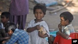 Indian street children eat food at a shanty town in Hyderabad, 13 Oct 2010.