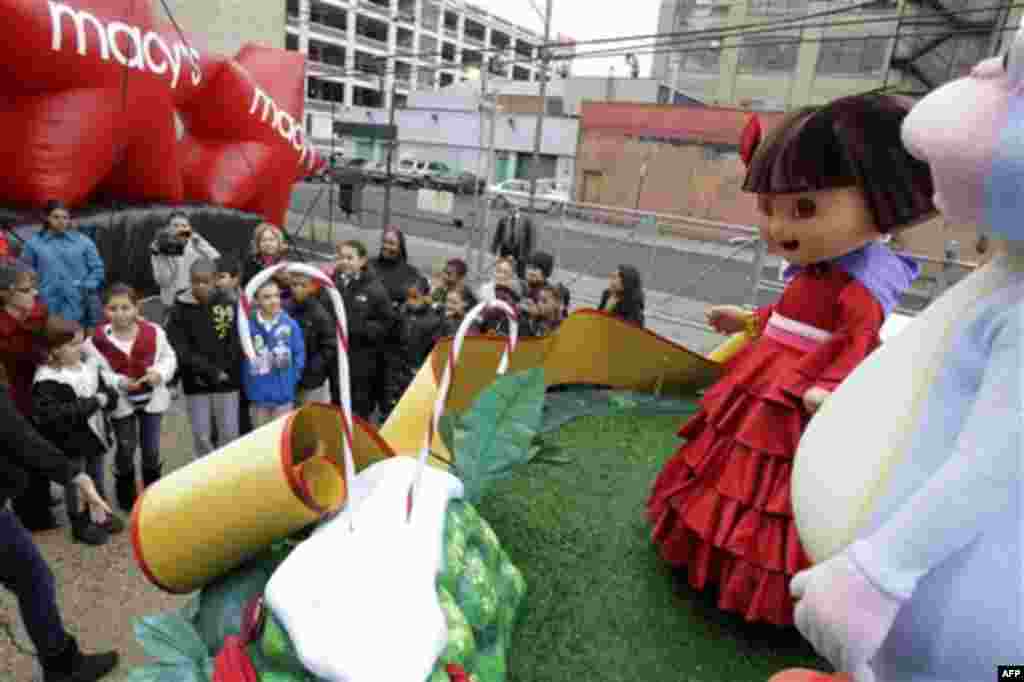 People dressed as the cartoon characters Dora the Explorer and Boots wave to visiting kids at the Macy's Parade Studio in Hoboken, N.J., Tuesday, Nov. 16, 2010. (AP Photo/Seth Wenig)