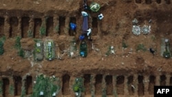 Gravediggers bury an alleged COVID-19 victim at the Vila Formosa Cemetery, in the outskirts of Sao Paulo, Brazil. 