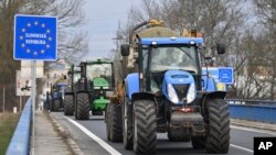 Agricultores checos en sus tractores se dirigen a un cruce fronterizo de la República Checa, el jueves 22 de febrero de 2024, para reunirse con sus colegas de los países vecinos y unir fuerzas en sus protestas contra las políticas agrícolas de la Unión Europea. 