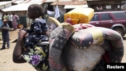 A woman carries her child in Minova, 45 kilometers west of Goma, DRC, November 26, 2012. 