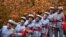 Women in replica red army uniforms have their picture taken as autumn leaves cover maple trees in Fragrant Hills Park in Beijing, China.