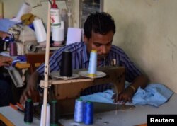 FILE - Rohingya refugee Muhammad Ayub sews clothes at a market in Kuala Lumpur, Malaysia, Aug. 15, 2016.