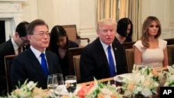 Le président Donald Trump, en compagnie de la première dame Melania Trump, à droite, reçoit le président sud-coréen Moon Jae-In, à gauche, lors d'un dîner dans la salle à manger de la Maison Blanche à Washington, le 29 juin 2017.