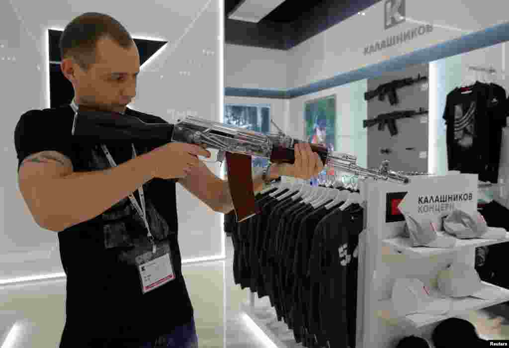 A salesperson demonstrates a model AK-47 assault rifle at the newly opened Gunmaker Kalashnikov souvenir store in Moscow&#39;s Sheremetyevo airport, Russia, Aug. 22, 2016.