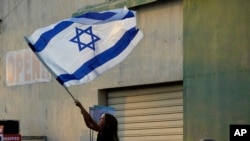 FILE - A girl waves an Israeli flag during a support rally outside the Jewish central Synagogue in the coastal town of Larnaca, Cyprus, October 17, 2023. 
