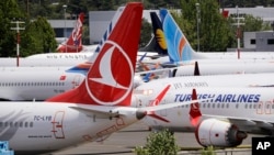 FILE - In this June 27, 2019, photo dozens of grounded Boeing 737 MAX airplanes crowd a parking area adjacent to Boeing Field in Seattle. 