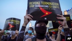 Demonstrators hold signs opposing the recent firings of Cathay Pacific employees during a demonstration at the Edinburgh Square in Hong Kong, Aug. 28, 2019. 