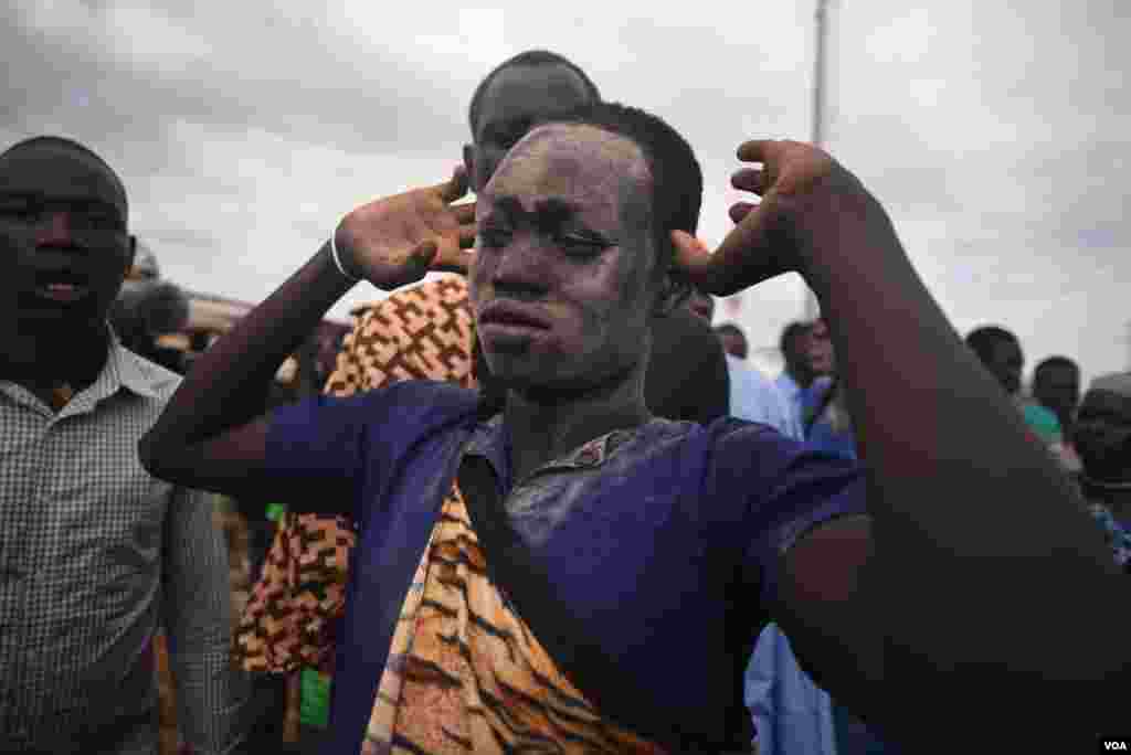 A Bor Dinka wrestler with ash on his face raises his arms before the "Wrestling for Peace" tournament at Juba Stadium in South Sudan's capital, April 16, 2016. (J. Patinkin/VOA)