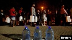 FILE - People queue to collect water from a spring in the Newlands suburb as fears over the city's water crisis grow in Cape Town, South Africa, Jan. 25, 2018.