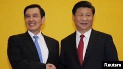 FILE - Chinese President Xi Jinping shakes hands with Taiwan's President Ma Ying-jeou during a Nov. 7, 2015, summit in Singapore. Leaders of political rivals China and Taiwan met Saturday for the first time in more than 60 years.