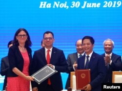 European Commissioner for Trade Cecilia Malmstrom, Romania's Business, Trade and Enterpreneurship Stefan Radu Oprea and Vietnam's Industry and Trade Minister Tran Tuan Anh attend the signing ceremony of EVFTA in Hanoi, June 30, 2019.