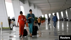 Pramugari Garuda Indonesia tiba di Terminal 3 pada hari pertama pengoperasian penerbangan domestik dari Bandara Soekarno-Hatta Airport, 9 Agustus 2016.