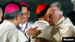 Pope Fransiskus (kanan) memeluk Kardinal Filipina Luis Antonio Tagle saat tiba di Markas Angkatan Udara Villamor di Manila, untuk kunjungan kenegaraan dan pastoralnya, Kamis (15/1).