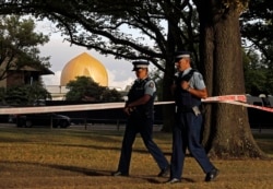 FILE - In this March 20, 2019, file photo, police officers patrol at a park outside the Al Noor mosque in Christchurch, New Zealand.