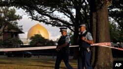 FILE - In this March 20, 2019, file photo, police officers patrol at a park outside the Al Noor mosque in Christchurch, New Zealand. 