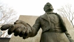 미국 오하이오주 애크론에 세워진 찰스 굿이어 동상. 오른 손에 고무 덩어리를 쥐고 있다.