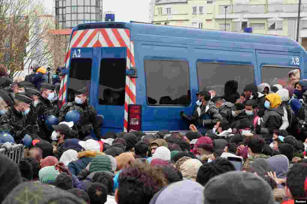 French gendarmes evacuate migrants from their makeshift camp near the A1 highway in Saint-Denis near Paris, Nov.17, 2020.