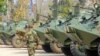 A Cambodian soldier walks past armored vehicles during the National Assembly members' visit to troops in a military base near the Preah Vhear temple in Preah Vihear province, some 500 kilometers northwest of Phnom Penh, February 9, 2011.