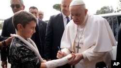 Виходячи з лікарні, де він лікувався від бронхіту, папа Франциск залишив автограф на гіпсовій пов’язці дитини. Рим, 1 квітня 2023 року. AP Photo/Gregorio Borgia
