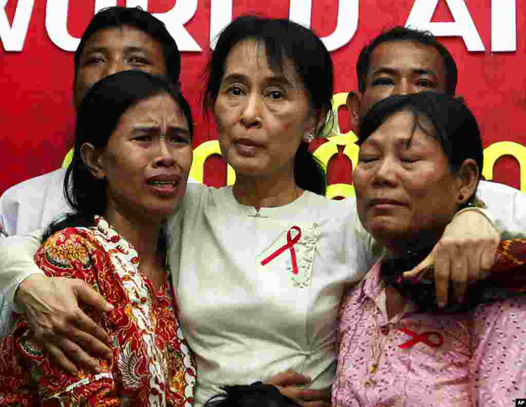 Aung San Suu Kyi (C) comforts HIV/AIDS infected people during a visit to the National League for Democracy party headquarters to mark World AIDS Day in Yangon December 2. (Soe Zeya Tun/Reuters)