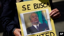 ARCHIVO - Un activista sostiene una fotografía del expresidente de Bolivia, Gonzalo Sánchez de Lozada, durante una protesta frente a la embajada de Estados Unidos en La Paz, Bolivia, el 3 de septiembre de 2010.