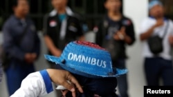 Seorang pekerja mengenakan topi saat mengikut demonstrasi menentang rencana pemerintah merevisi Undang-Undang Ketenagakerjaan, di luar gedung DPR/MPR, Jakarta, 20 Januari 2020. (Foto: Reuters)